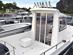 Ein Boot mit Kabine, kleinem Deck und einem Motor am Heck.