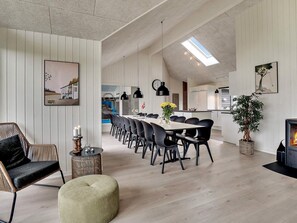 A spacious living area with a dining table, chairs, a sofa, and a fireplace.