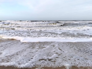 A beach with waves and foam, no buildings or people visible. - 5 Star Holiday Home in Ringkobing (Ringkobing)