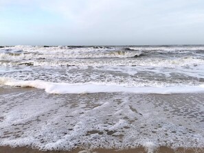 A beach with waves and foam, no buildings or people visible. - 5 Star Holiday Home in Ringkobing (Ringkobing)