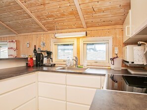 A kitchen with wooden ceiling, a coffee machine, a sink, and a window. - 5 Person Holiday Home in Otterup (Otterup)