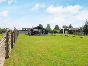 A residential property with a fenced yard, a wooden deck, and a house with a dark exterior. - 5 Person Holiday Home in Otterup (Otterup)