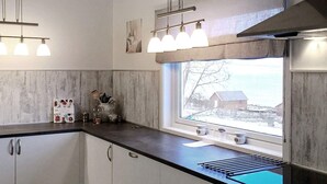 A modern kitchen with a window, cabinets, and a countertop.