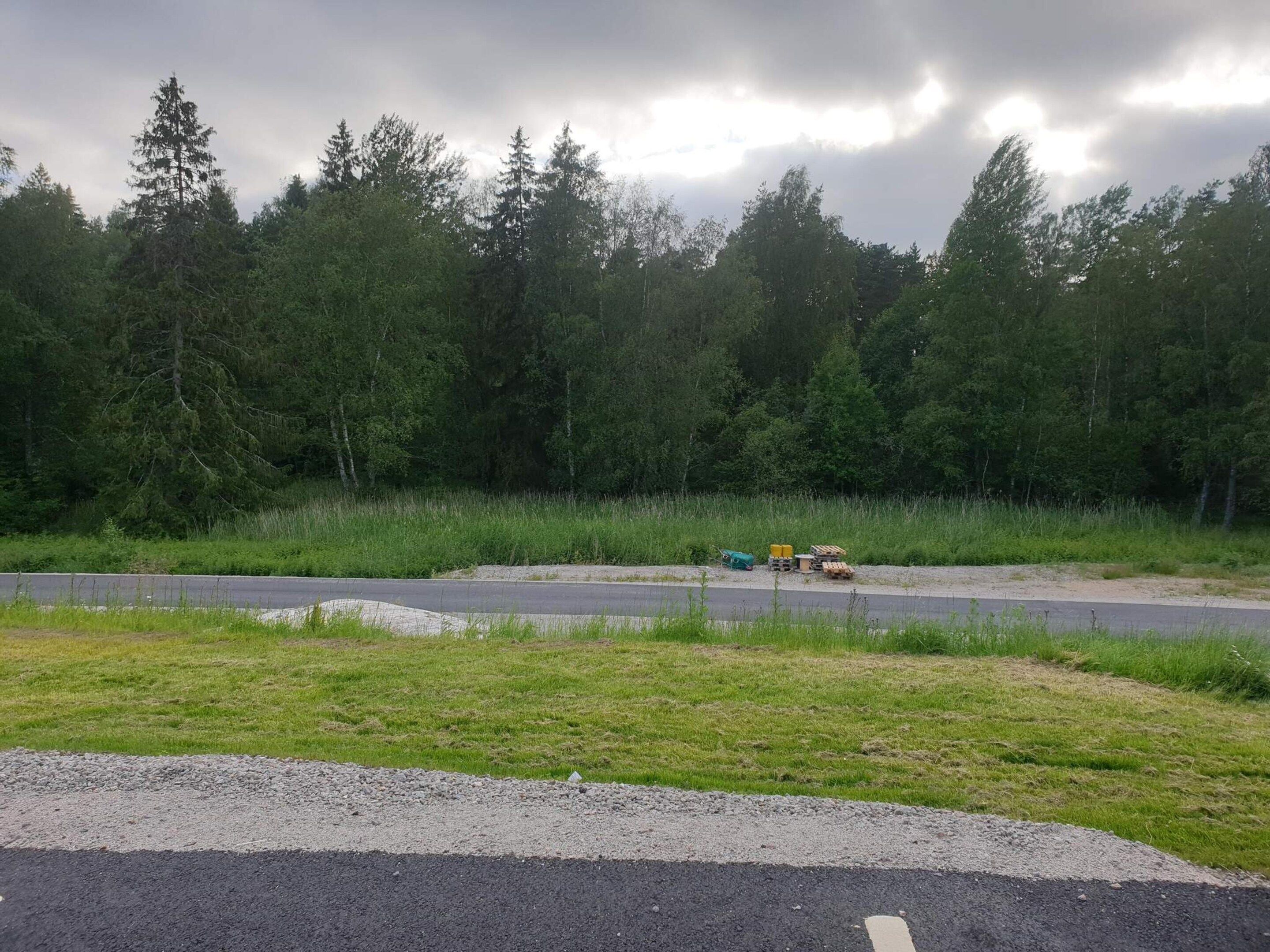 Une route avec une bande d’arrêt d’urgence en gravier et un tas de matériaux de construction.