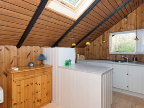 A compact kitchen with wooden cabinetry, a central island, and a skylight. - 6 Person Holiday Home in Farvang (Farvang)