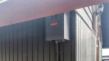 A building with a metal exterior and a red sign on a utility box.