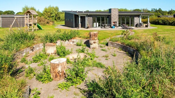 A modern house with a patio, a play structure, and a stone pathway. - Luxury Lakeside Retreat With Spa-by Traum (Glesborg)