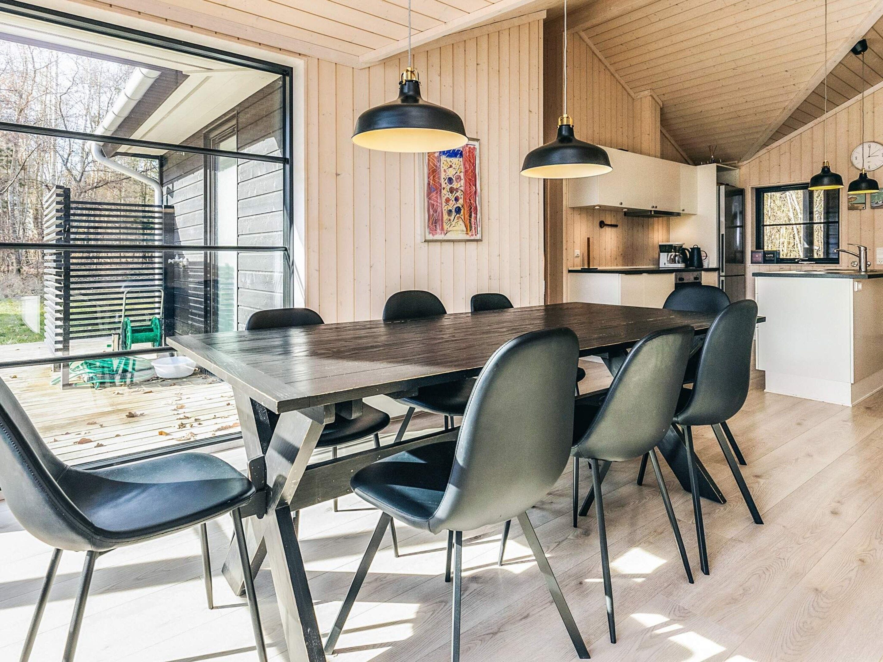 Una cocina moderna con armarios de madera, una isla grande e iluminación colgante.