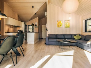 Um interior moderno com área de refeições, cozinha e sala de estar.
