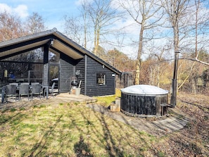 Uma cabana moderna com área de varanda, hidromassagem e deck.