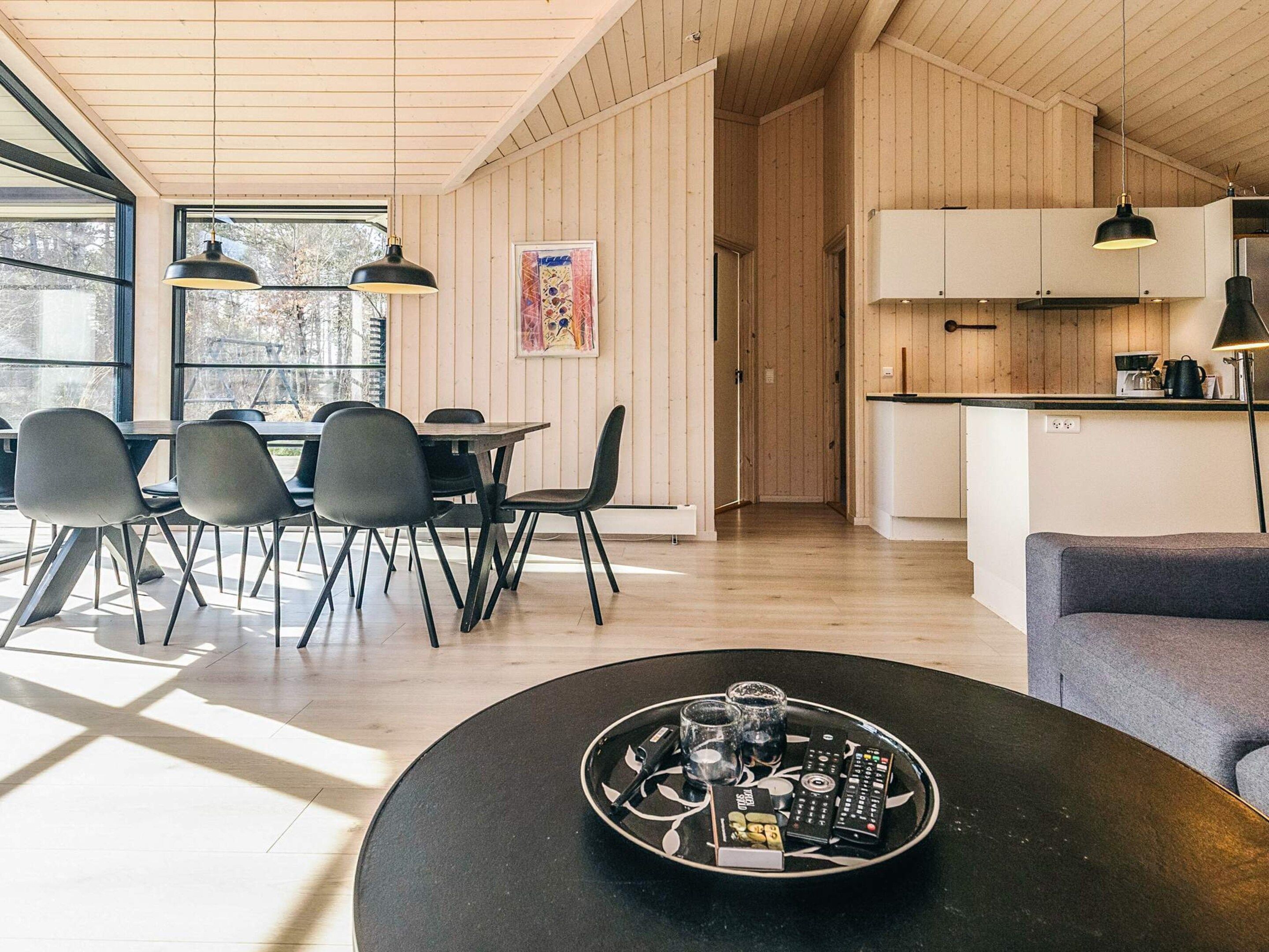 En modern inredning med matplats, kök och sittgrupp.