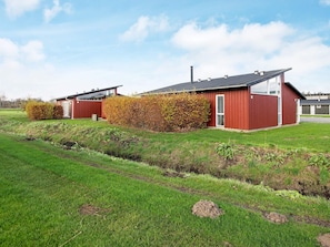 A modern building with a red exterior, a flat roof, and a clear sky. - 5 Star Holiday Home in Bogense (Bogense)