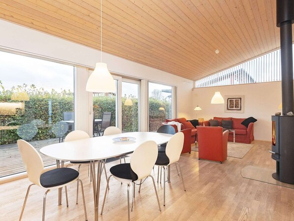 A modern interior with a dining area, sofas, and a fireplace.