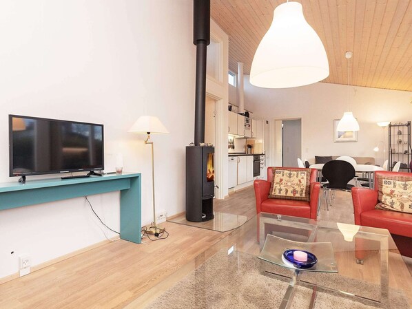 Un salon moderne avec un téléviseur, un canapé, une table basse et une cheminée.