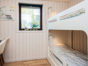 A bunk bed room with a window, a desk, and a whiteboard.