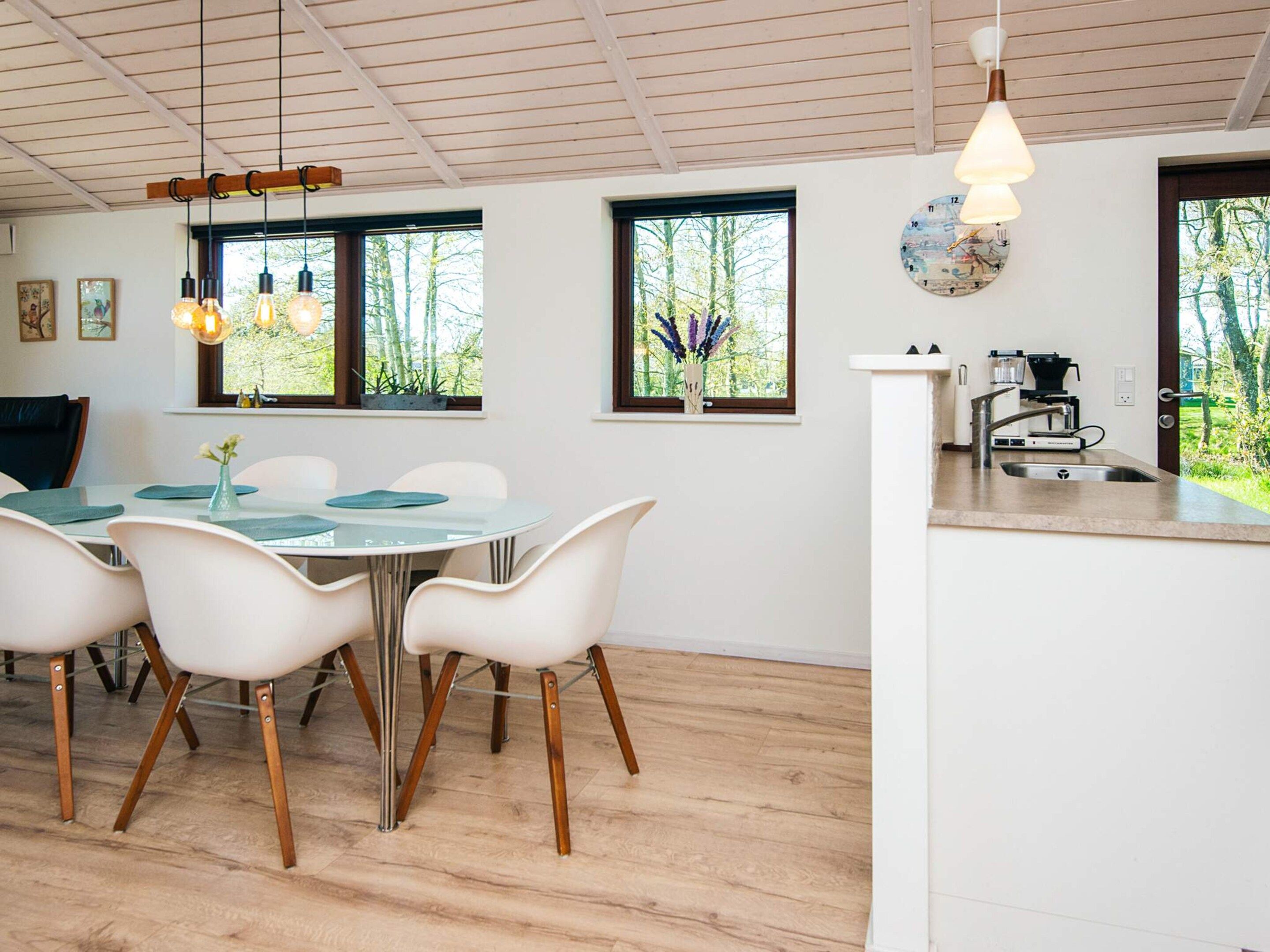 A modern kitchen with a white countertop, stainless steel sink, and a built-in oven.