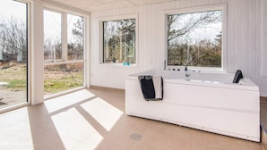 A modern bathroom with a large bathtub, large windows, and a view of the outdoors. - 12 Person Holiday Home in Ebeltoft (Ebeltoft)