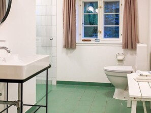 A bathroom with a white sink, a toilet, and a window with curtains. - 5 Star Holiday Home in Laeso (Læsø)