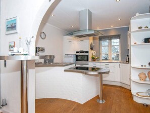 A modern kitchen with white cabinetry, a central island, and a stainless steel range hood. - 6 Person Holiday Home in Broager (Broager)
