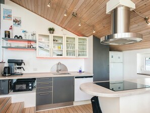 A modern kitchen with a built-in microwave, a coffee maker, and a sink. - 5 Star Holiday Home in Ebeltoft (Ebeltoft)