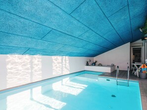 An indoor swimming pool with a blue ceiling and a stone wall. - 5 Star Holiday Home in Ebeltoft (Ebeltoft)