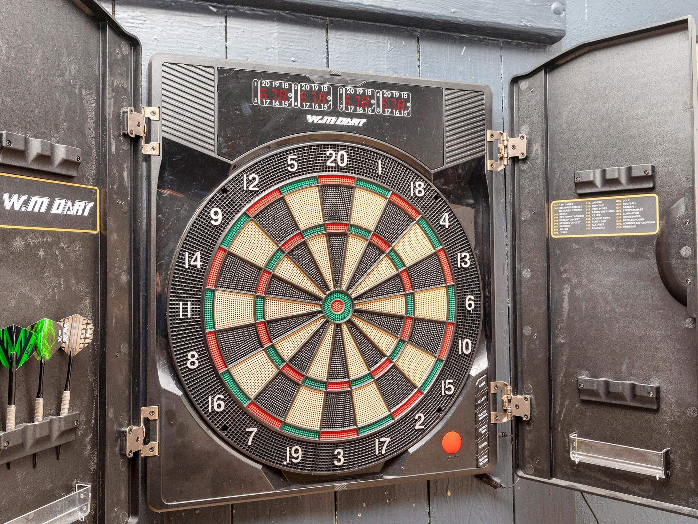 A dartboard mounted on a wall with a scoreboard above it.
