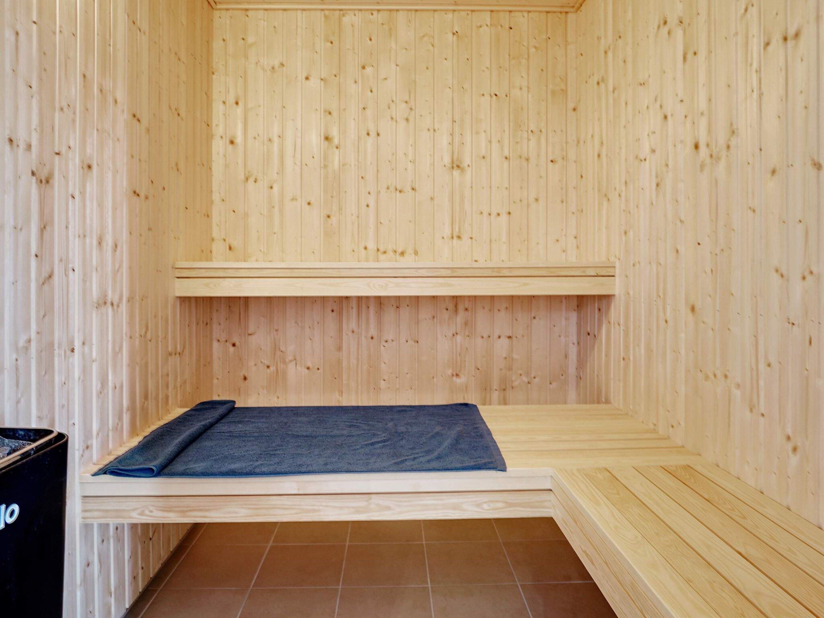 Una sala de sauna con paredes de madera y un banco.