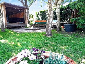 A garden with a wooden shed, a wheelbarrow, and a planter with flowers. - 4 Star Holiday Home in Sydals (Sydals)