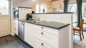 A modern kitchen with white cabinets, a stainless steel sink, and a large window.