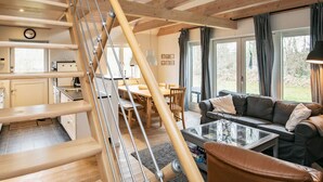 A wooden staircase leading to a dining area with a view of the outdoors.