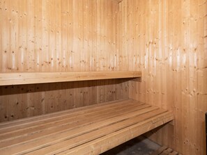 A sauna room with wooden walls and benches.