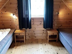 A room with wooden walls and a sloped ceiling, featuring two beds, two bedside tables, and a window with curtains. - 6 Person Holiday Home in Seim (Alver)