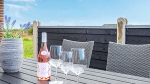 A table with a bottle of wine, glasses, and a potted plant. - 16 Person Holiday Home in Ulfborg (Ulfborg)