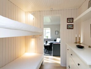 A room with a bunk bed, a desk with a chair, a dresser, and a window with a view of another room. - 4 Person Holiday Home in Assens (Assens)