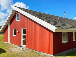 A red building with a sloped roof, a chimney, and a small porch area. - 4 Star Holiday Home in Nordborg (Nordborg)