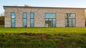 Un bâtiment moderne avec une façade en briques et de grandes fenêtres.
