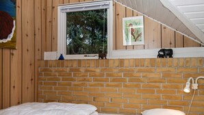 A bedroom with a brick wall, a window, a bed, and a nightlight. - 6 Person Holiday Home in Ebeltoft (Ebeltoft)