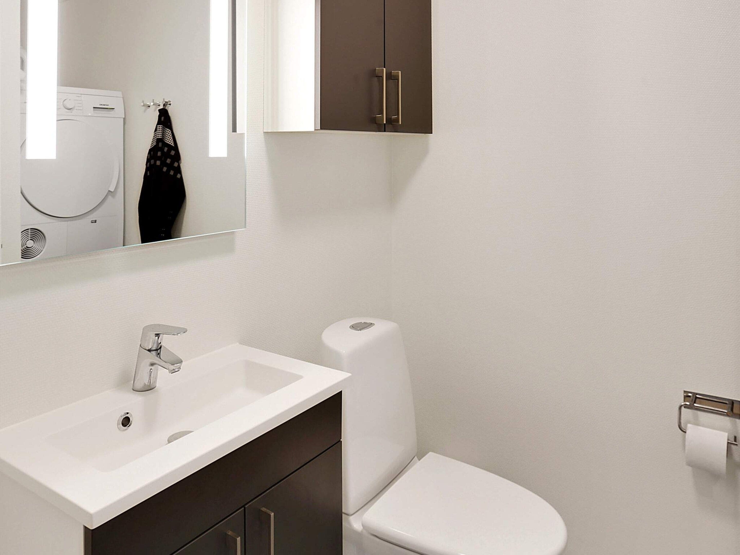 Ein Badezimmer mit Waschbecken, Toilette und Spiegel.