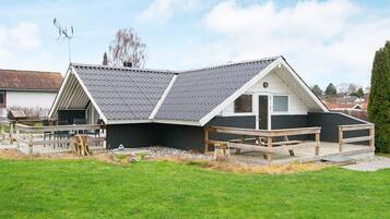 A house with a sloped roof, a deck, and a fenced yard.