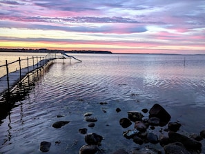 A pier extending into calm water with a sunset sky. - 5 Person Holiday Home in Hejls (Hejls)