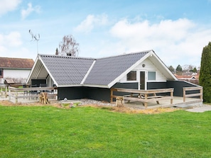 A house with a sloped roof, a deck, and a fenced yard. - 5 Person Holiday Home in Hejls (Hejls)