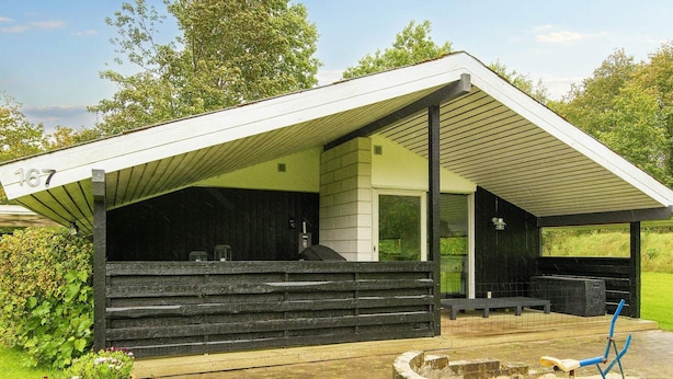 A modern building with a covered outdoor area, steps leading to a door, and a number '167' sign. - 6 Person Holiday Home in Farvang (Farvang)