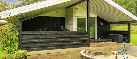 A modern house with a covered porch, a number '167' sign, and a stone well.