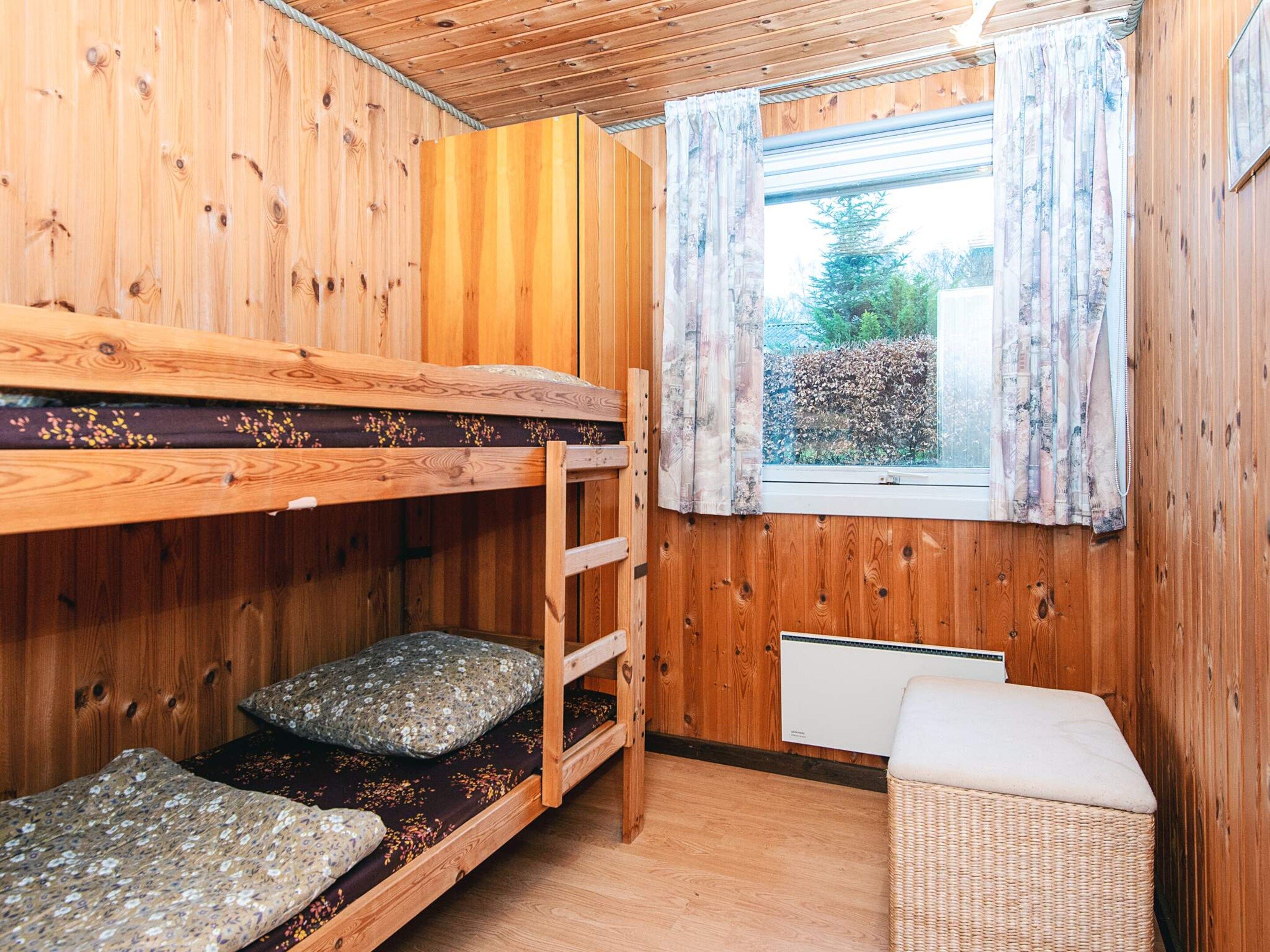 Habitación con literas, ventana y radiador.