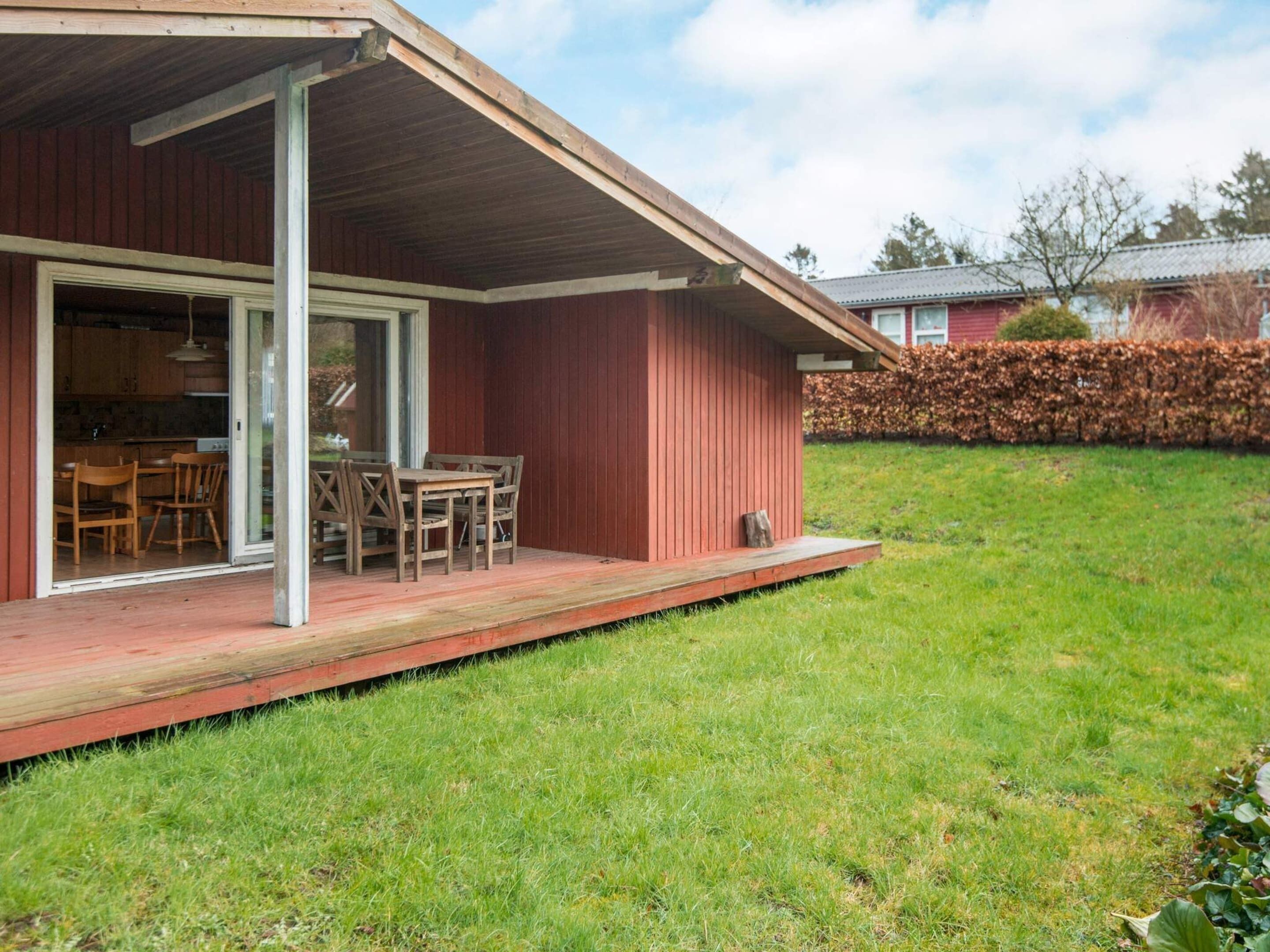 A wooden house with a covered porch and a dining area.
