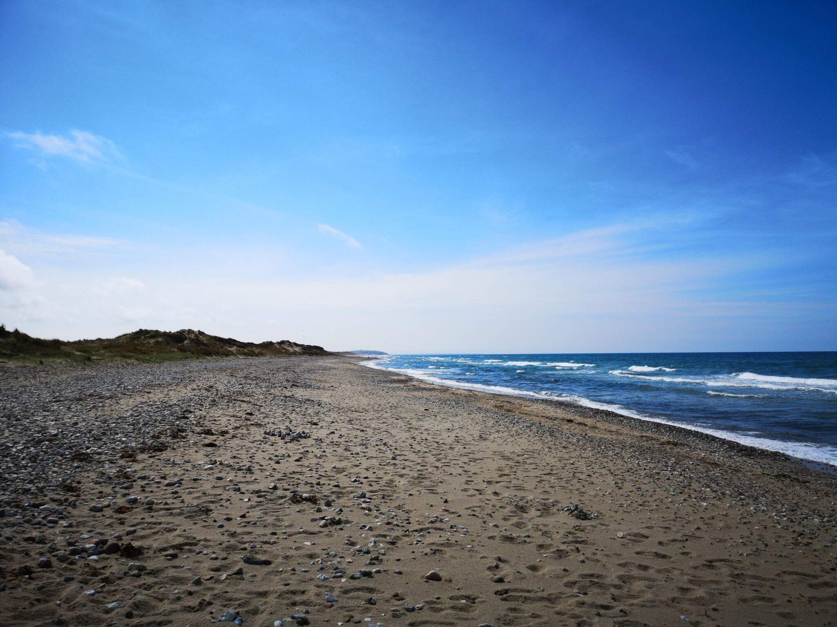 A beach with a pebbly shore and waves.