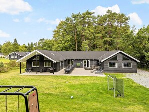 A modern two-story house with a patio area, outdoor seating, and a soccer goal. - 5 Star Holiday Home in Frederiksvaerk (Frederiksvaerk)