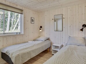A room with two beds, a window, a wall-mounted mirror, and a bedside table. - 5 Star Holiday Home in Frederiksvaerk (Frederiksvaerk)