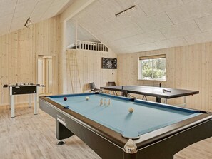 A pool table with a dartboard and a foosball table in a room with wooden walls and a sloped ceiling. - 5 Star Holiday Home in Frederiksvaerk (Frederiksvaerk)