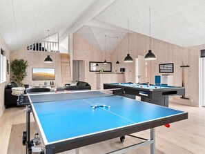 A spacious indoor area with a ping pong table, a pool table, and a billiards table.
